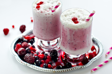 Fresh milk shake with syrup and frozen  berries in glas