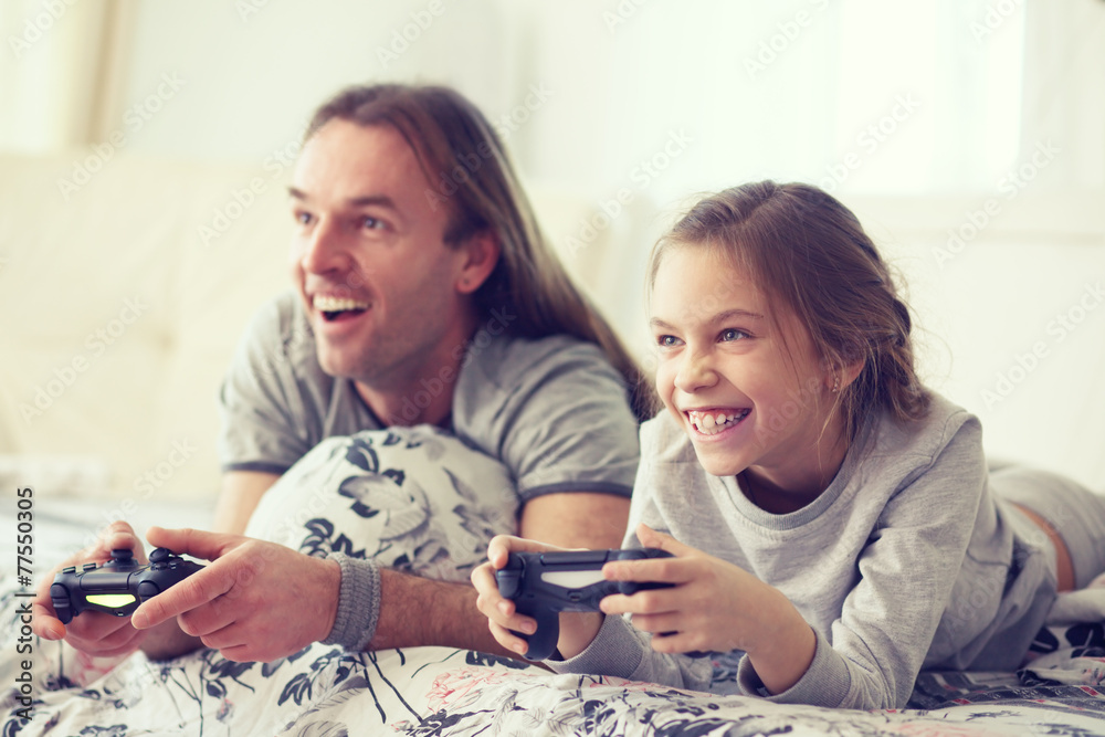 Wall mural Child playing video game with father