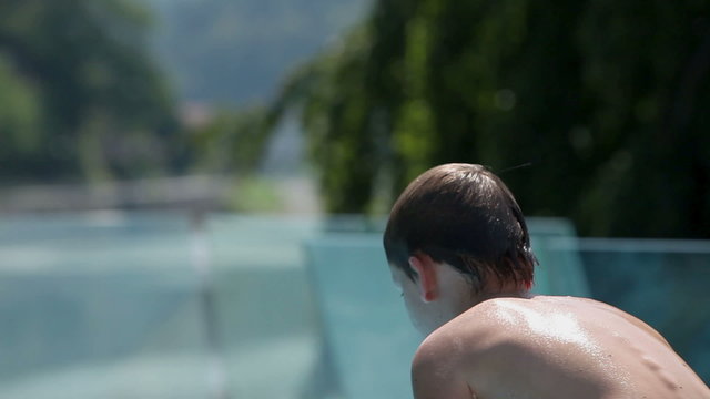 Young boy preparing to jump in to pool water