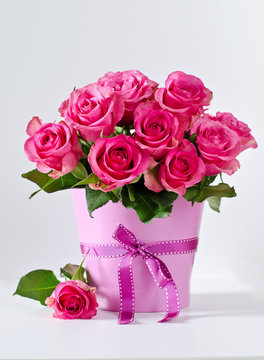 Bunch of pink roses in pink vase copy space background