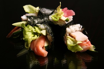 sashimi and rolls on black background