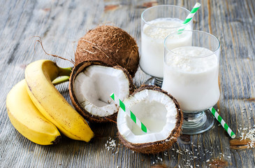 Coconut milk smoothie drink with bananas on wooden background - 77551373