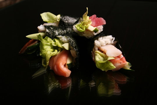 sashimi and rolls on black background