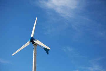 Green renewable energy concept - wind generator turbines on blue