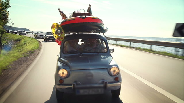 Small car filled with children toys,  road toward beach