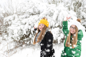 Two Tween Girls throwing snowballs