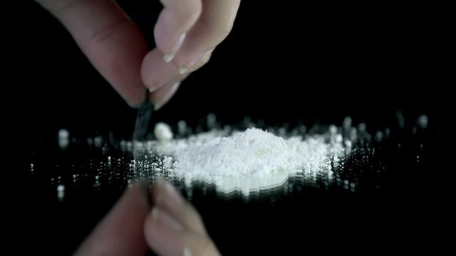 Female preparing cocaine for consumption