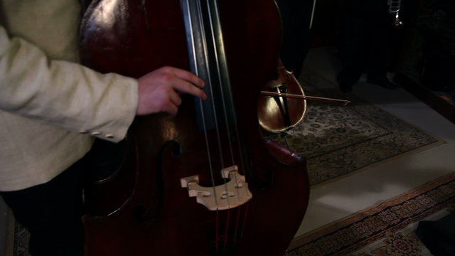Close up pan shot of a bass player