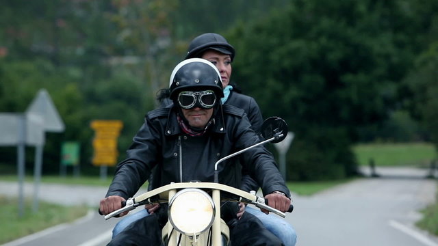 Middle aged couple on retro motorcycle