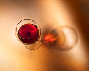 Calice di vino rosso su fondo caldo con ombra.Vista dall'alto - obrazy, fototapety, plakaty