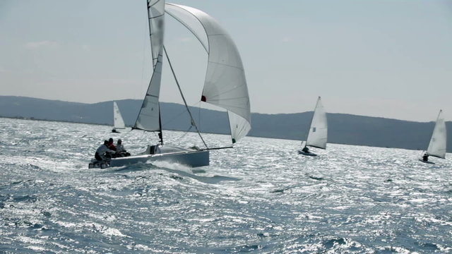 Three people on sailboat enjoying the sailing on beautiful day