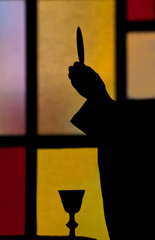 priest lifting host silhouette