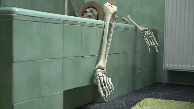 Skeleton laying in the bathtub taking care of his hygiene
