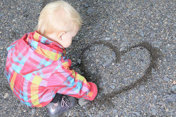 Naklejka premium young girl holding gravel in shape of heart (shallow depth of