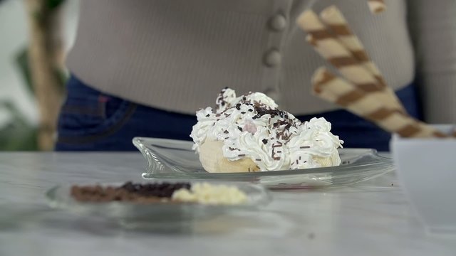 Putting sweet stick into the ice cream on a plate