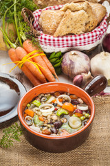 Rural vegetarian broth soup with colorful vegetables and rustic