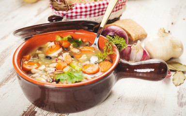 Rural vegetarian broth soup with colorful vegetables and rustic