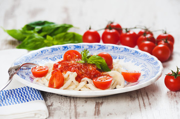 Healthy plate of Italian spaghetti topped with a tasty tomato an