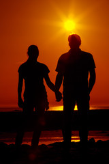 Fototapeta na wymiar Zwei im Sonnenuntergang halten Händchen