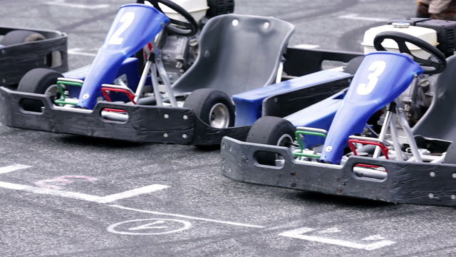 Blue go-carts parked at the starting line on a racing track