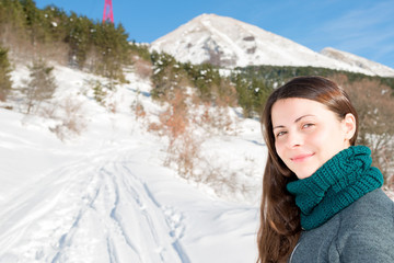Fototapeta na wymiar A smiling girl on a snowy trail shows the way, Abruzzo Italy