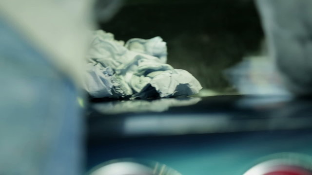 Polishing the blue Corvette with white cloth