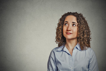 woman thinking looking up isolated on grey wall background 