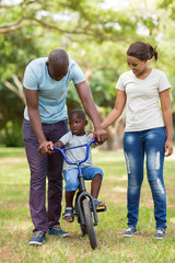 Fototapeta premium young parents teaching their son to ride a bicycle