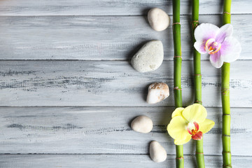 Orchid flowers  and bamboo with pile stones on wooden