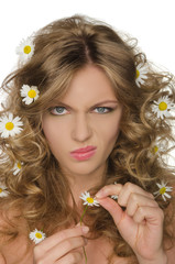 Fototapeta premium unhappy woman with daisies in hair takes petals