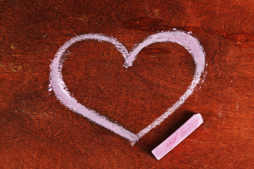 Heart drawn of chalk on wooden background close-up