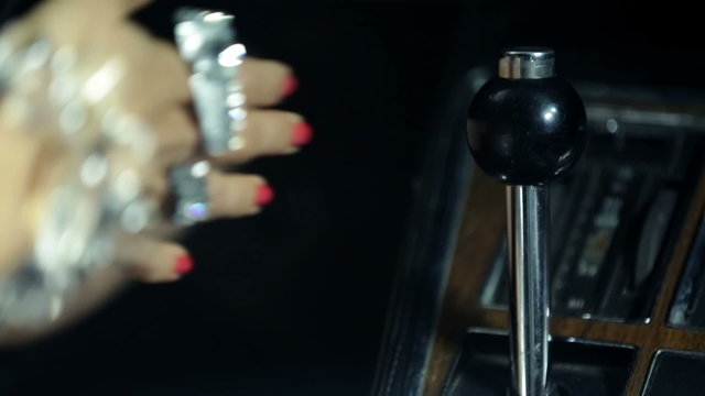 Detail shot of woman changing the gear in blue Corvette
