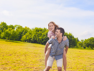 Portrait of Happy and Cheerful Young Caucasian Couple Piggybacki