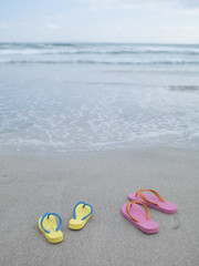 Fototapeta na wymiar Sandy beaches and two pairs of beach sandals