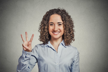 woman showing three fingers sign gesture grey background 