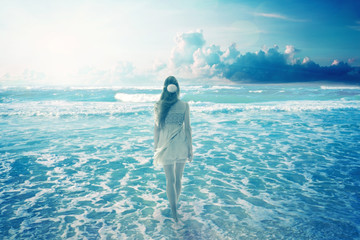 Woman walking on dreamy beach enjoying ocean view