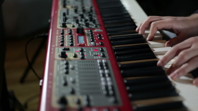 close up shot of musican playing keyboards