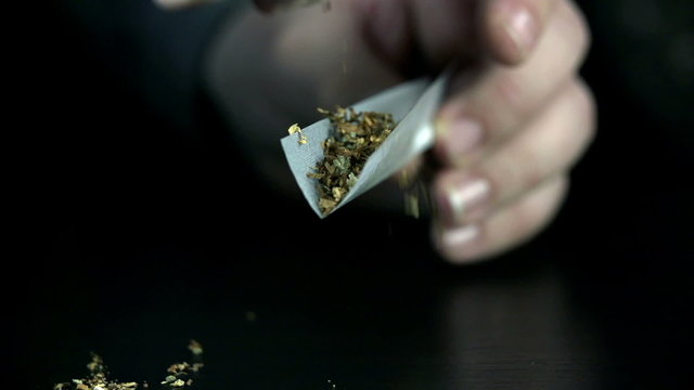 Spreading marihuana over tobacco in rolling paper