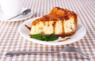 Cheese cake and cup of coffee on tablecloth closeup