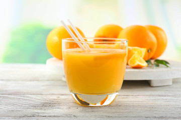 Glass of orange juice with straw and slices