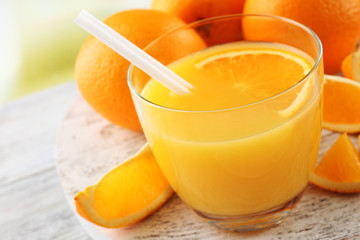 Glass of orange juice with straw and slices
