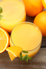 Glass of orange juice and slices on wooden table background