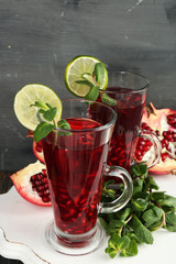 Pomegranate drink in glasses with mint and slices of lime