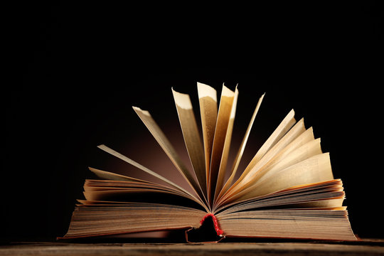Open book with light over dark background