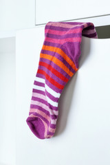Stripped sock hanging on closet background