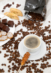 The coffee cup with dish of chocolate sweets and cookies