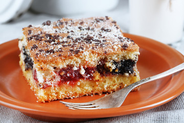Homemade pie with jam and glass of milk on tablecloth