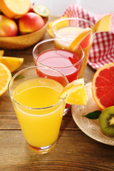 Fresh juices with fruits on wooden table