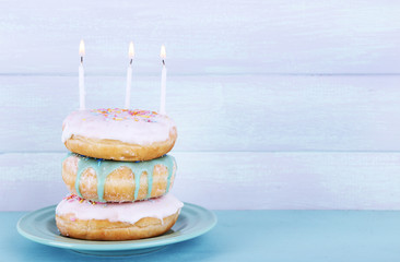 Delicious donuts with icing and birthday candles
