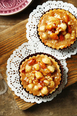 Mini cakes with nuts on wooden background